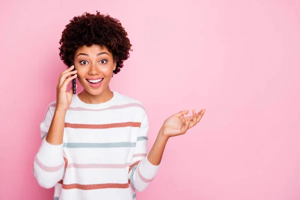 Foto de muito animado escuro pele senhora segurando telefone falando com melhor amigo desgaste branco listrado pulôver isolado pastel cor-de-rosa fundo — Fotografia de Stock