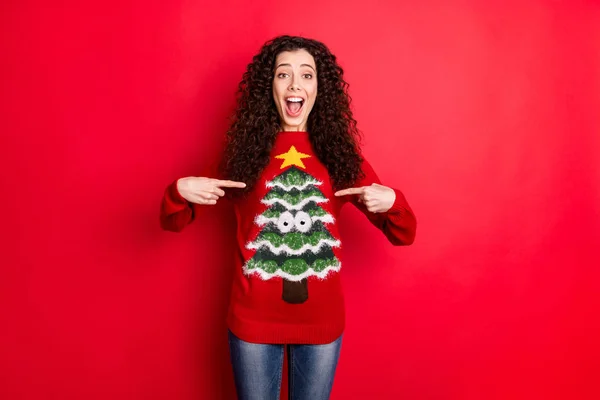 Portrét legrační funky dívka bod na její stylové pohodlí útulný sezóna oblečení svetr s vánoční stromeček výkřik wow omg izolované nad červenou barvou pozadí — Stock fotografie