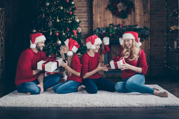 크리스마스 소원을 확인합니다. 큰 가족 아빠 엄마 동생 동생이 X-mas 선물을 주는 사진 장식 화환 조명 신년 나무 실내 에서 산타 캡 빨간 스웨터를 입고 바닥에 앉아 — 스톡 사진
