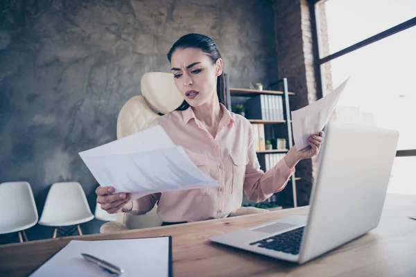 Baixo ângulo ver foto do empresário triste chateado infeliz comparando papel contábil de dois períodos sentados antes do laptop no desktop franzir a testa com mal-entendido — Fotografia de Stock