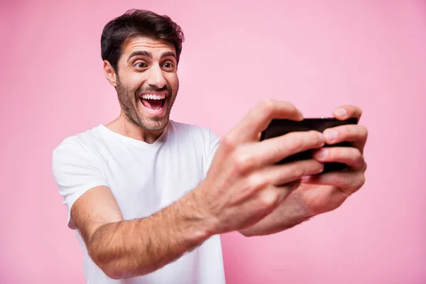 ファンキーな面白い面白い陽気な中東の男ホールドの肖像画使用彼のスマートフォンゲームインターネットビデオゲームレースウェアスタイルの衣装ピンク色の背景に隔離された — ストック写真