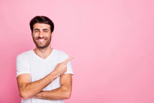 Retrato de positivo alegre fresco del hombre de oriente medio dedo índice de espacio de copia indican descuentos en anuncios usan ropa blanca aislada sobre fondo de color rosa — Foto de Stock