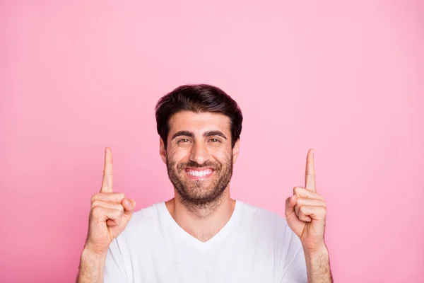 Cerca de la foto de positivo alegre hombre de Oriente Medio apuntar hacia arriba el espacio de copia dedo recomendar anuncios promoción desgaste camiseta blanca aislada sobre fondo de color rosa — Foto de Stock