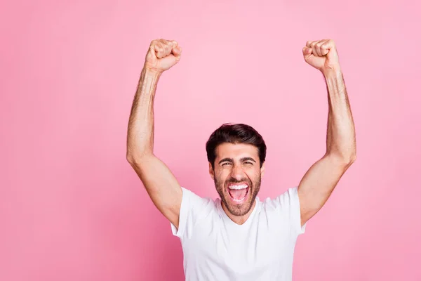 Retrato de divertido extático funky loco afortunado hombre de Oriente Medio levantar los puños grito sí ganar la competencia tienen celebración usar camiseta blanca aislada sobre fondo de color rosa — Foto de Stock