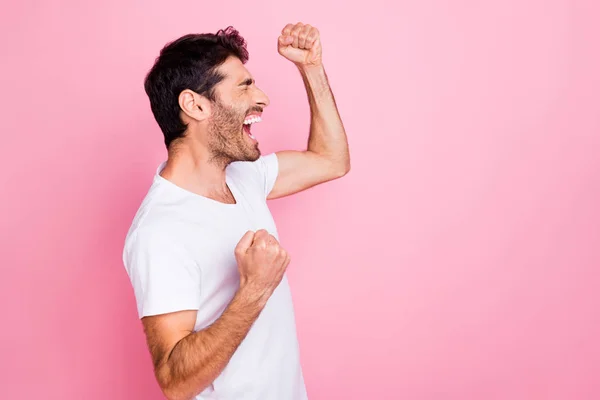 Siamo bth champions. Profilo lato foto di felice uomo arabo gridare sì alzare i pugni si sentono euforia per la vittoria indossare vestiti bianchi t-shirt isolato su sfondo di colore rosa — Foto Stock