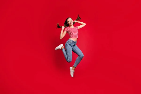 Teljes hossz testméret fotó gyönyörű izgatott vidám aranyos barátnő játszik a haját, miközben elszigetelt vörös háttér — Stock Fotó