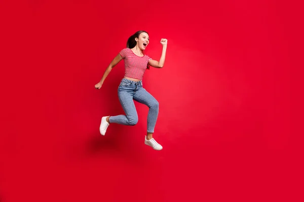 Πλήρες μήκος σώματος μέγεθος φωτογραφία του χαρούμενα γοητευτικό χαριτωμένο όμορφη τρελή φίλη φορώντας τζιν τζιν ενώ απομονώνονται με κόκκινο φόντο — Φωτογραφία Αρχείου
