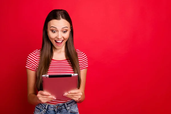 Copyspace foto di stupito bella fidanzata interessata vedere sconti nel suo tablet mentre isolato con sfondo rosso — Foto Stock