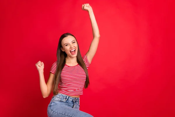 Foto de animado alegre campeão namorada vestindo jeans jeans enquanto isolado com fundo vermelho regozijando-se alegrou — Fotografia de Stock