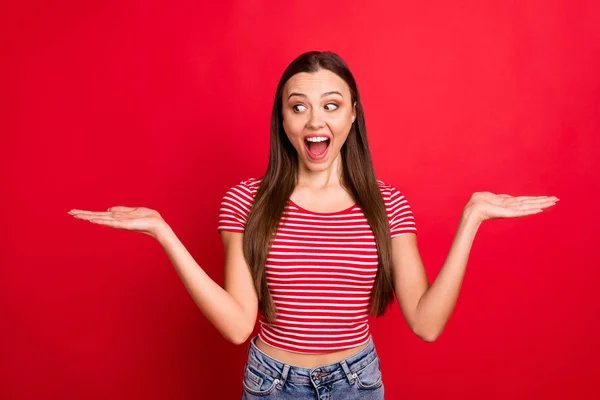 Photo of cheerful white trendy nice cute girl looking at one of sides of choices screaming while isolated over red background — Stock Photo, Image