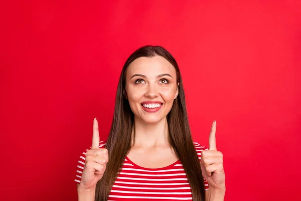 Tutup foto menarik menarik gadis ceria positif untuk menunjukkan sesuatu yang menguntungkan di atas sementara terisolasi dengan latar belakang merah — Stok Foto