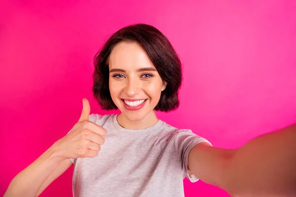 Auto foto de alegre bonito agradável bonita doce atraente namorada sorrindo toothily polegar para mostrar como a alta qualidade é, enquanto isolado com fundo cor brilhante fúcsia levando selfie — Fotografia de Stock