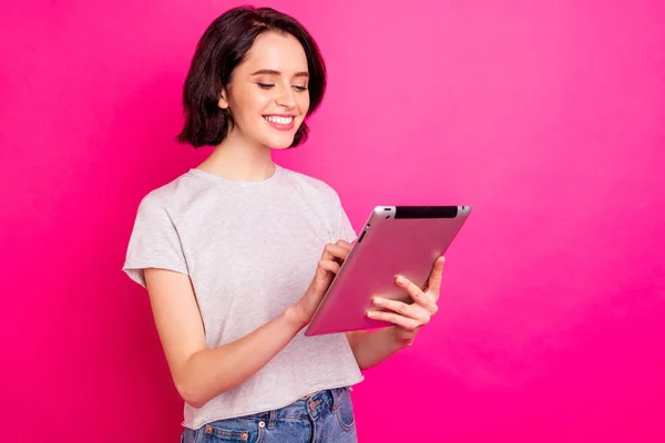 흰색 티셔츠를 입고 핑크 색 배경으로 고립된 대학생 프로젝트에 대한 태블릿읽기 뉴스 검색 정보를 사용하여 만족 한 여학생의 사진 — 스톡 사진
