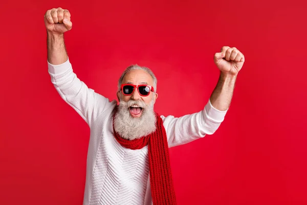 Retrato de jubilado encantado en gafas gafas gafas gritando sí levantando puños celebrando la victoria usando jersey blanco aislado sobre fondo rojo — Foto de Stock