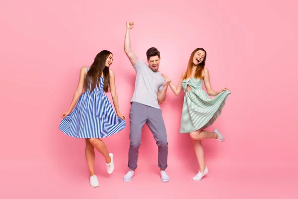 Teljes hosszúságú fotó a boldog férfi felemeli öklét sikoltozó és táncoló lányok hosszú foxy gyömbér frizura elszigetelt rózsaszín háttér — Stock Fotó