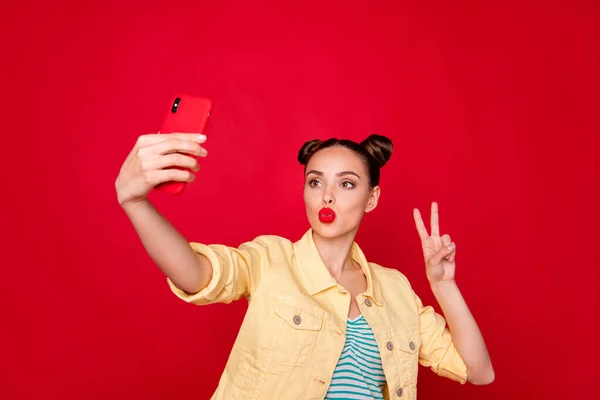 Foto von hübschen Dame hält Telefon Hände machen Selfies, die V-Zeichen tragen lässiges Outfit isoliert roten Hintergrund — Stockfoto