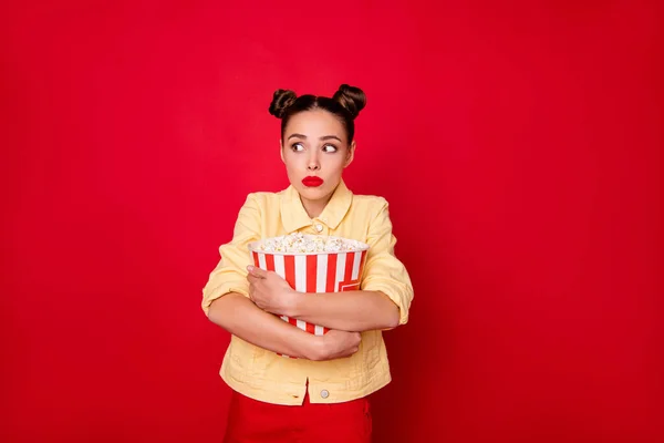 Bonita dama sosteniendo palomitas de maíz contenedor miedo todo después de la película de miedo desgaste traje casual aislado fondo rojo — Foto de Stock