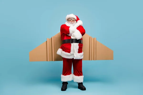 Tam boy vücut ölçüsü. Güzel, şişman, havalı, neşeli Aziz Nicholas Noel Baba 'nın uçak kanatları takan, hızlı nakliye atölyesi teslimat hizmeti. Mavi pastel arka planda izole edilmiş kollar. — Stok fotoğraf