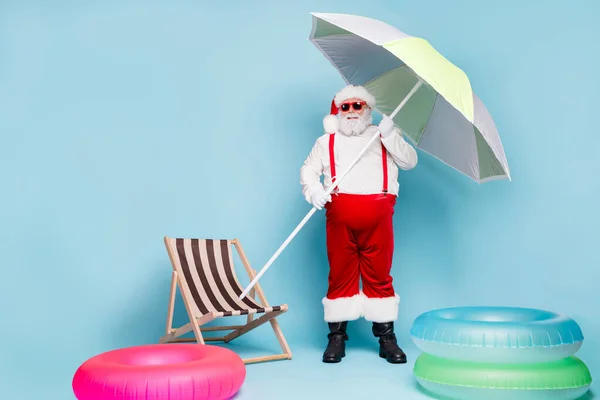 파란 청록색 파스텔 색 배경 위에 고립된 우산 해변 파티 관광을 하고 있는 그 의 시원하고 상쾌 한 산타 여행객의 전체 몸길이 — 스톡 사진