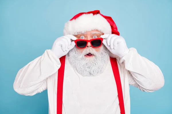 Close-up foto van onder de indruk vet overgewicht santa claus staren in moderne bril kijken grappig funky horen wonder kerst seizoensgebonden kortingen dragen bretels overall geïsoleerd over blauwe kleur achtergrond — Stockfoto