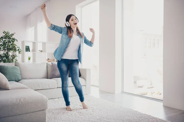 Full längd foto av fantastisk dam lyssnar favorit melodi i moderna öronlappar dans överlycklig i ljus rum bär jeans kläder lägenhet inomhus — Stockfoto