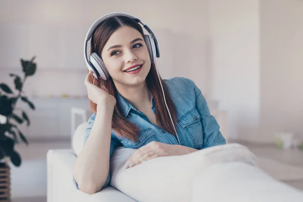 Närbild foto av fantastisk dam i hög sprit lyssna favorit melodi i moderna öronlappar sitter bekväm soffa bär jeans kläder lägenhet inomhus — Stockfoto