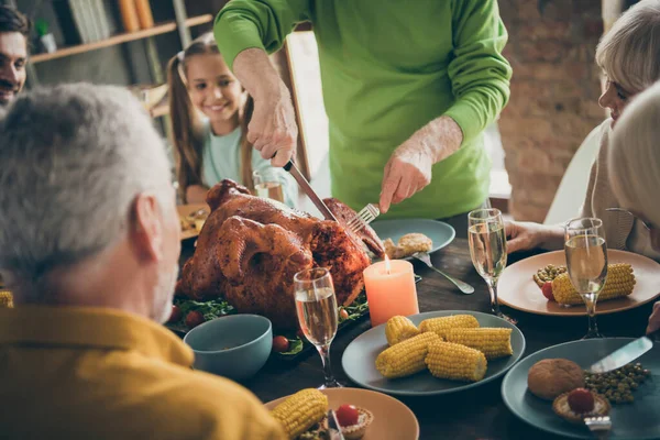Photo recadrée de la famille pleine table de repas assis près de dinde rôtie grand-père couper la viande en tranches parents affamés attendant excité à partir de dans le salon à l'intérieur — Photo