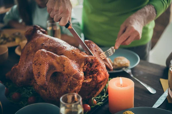 Foto recortada de la fiesta familiar pavo asado en las manos del abuelo mesa cortar la carne en rodajas parientes hambrientos esperando en la sala de estar en el interior — Foto de Stock