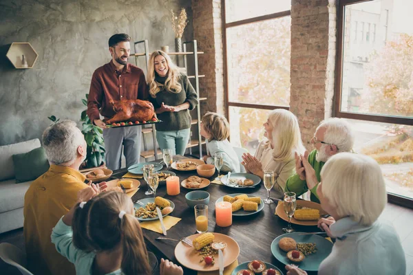 Foto von vollständigen Familientreffen sitzen Festteller Tisch treffen große gebratene Truthahn Ovationen klatschen Hände Mehrgenerationenhaus acht Verwandten jährliche Veranstaltung im Wohnzimmer drinnen — Stockfoto