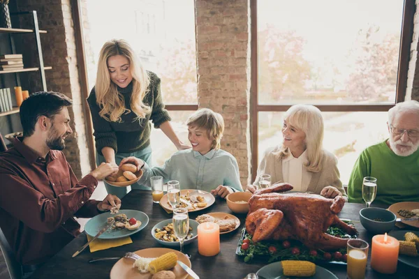 Joyeux Thanksgiving. Photo de grande famille rassemblement assis fête repas dîner table femme donnant tout le monde pain frais cuit multi-génération dans le salon du soir à l'intérieur — Photo