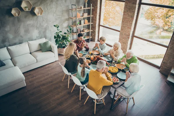 Top above high angler photo of serious dreamy large family meeting retired people preteen kids meeting sit table have thanksgiving celebration enjoy meal roasted chicken poultry pray in house — Stock Photo, Image