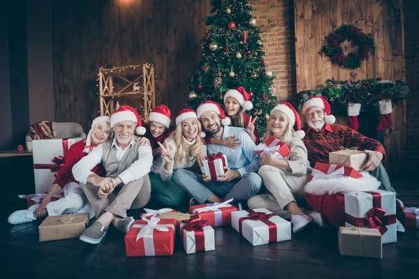 Retrato de agradável charmoso alegre grande família completa irmão casais vestindo chapéu chapéu headwear sentado no chão inverno tradição mostrando v-sinal no loft decorado estilo industrial interior casa — Fotografia de Stock