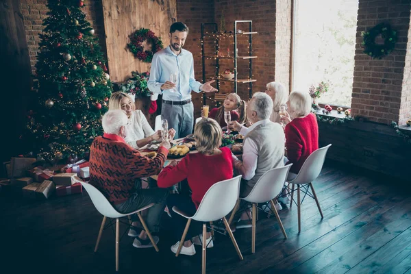 Foto av hela familjen sammankomst sitta middag bord far kille berättar jul rostat bröd flera generationer åtta medlemmar i nyår jul sprit vardagsrum inomhus — Stockfoto