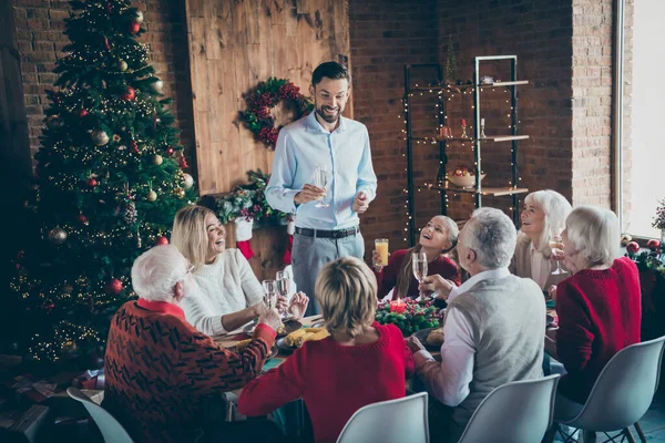 フル大家族の集まりの写真は、屋内で新年の装飾されたリビングルームでx-masトースト多世代8人のメンバーの調和を伝えるディナーテーブルの父親男に座る — ストック写真