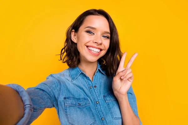 Close up foto de alegre positivo funky menina tomar selfie fazer v-sinais mostrar saudações aos seus seguidores do blog usar jeans jeans camiseta isolada sobre fundo de cor amarela — Fotografia de Stock