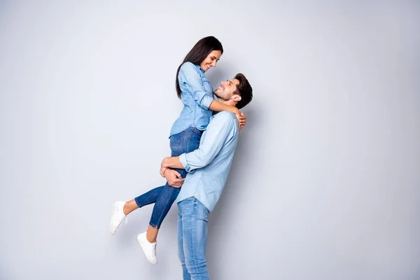 Foto av rolig kille som håller dam i starka armar bästa par romantik ögonblick före första kyssen bära casual jeans kläder isolerad grå färg bakgrund — Stockfoto