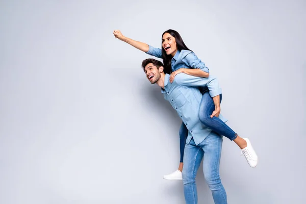 Zdjęcie fajnej pary facet gospodarstwa lady piggyback udając lot w górę za pomocą super mocy nosić casual jeansy ubrania odizolowane szary kolor tła — Zdjęcie stockowe