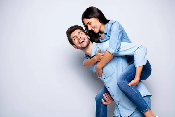 Foto de perfil de cara incrível e senhora segurando piggyback jogando lazer jogo desgaste casual jeans roupas isolado fundo de cor cinza — Fotografia de Stock