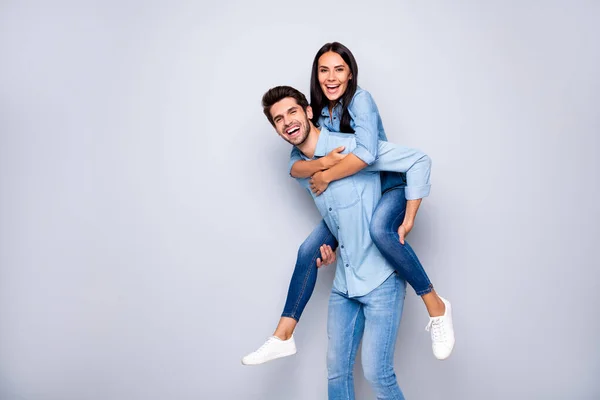 Foto de perfil de tipo divertido y la señora que sostiene a cuestas jugando juego de ocio regocijo desgaste casual jeans ropa aislado color gris fondo — Foto de Stock