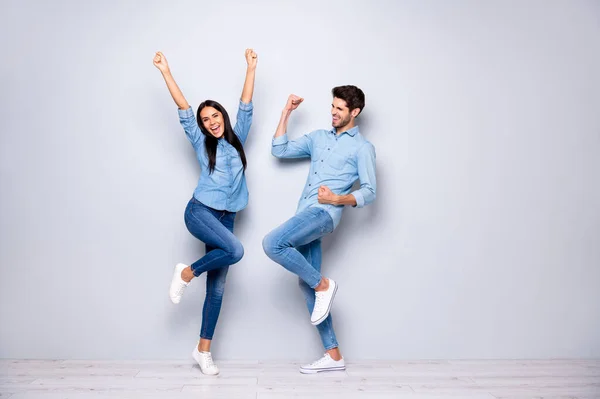 Volledige lengte foto van man en vrouw vieren beste overwinning hijsen vuisten lucht dragen casual jeans kleding geïsoleerde grijze kleur achtergrond — Stockfoto