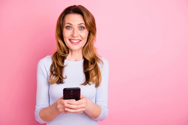 明るい正の女性の肖像は彼女の携帯電話を使用して信じられないほどのフィードバックを読んで楽しい感じピンク色の背景に隔離された白いプルオーバーを着用 — ストック写真