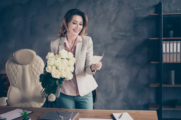 Retrato de ella ella agradable atractiva alegre alegre señora madura sosteniendo en las manos rosas blancas lectura romance postal profesional día de fiesta en el estilo industrial interior lugar de trabajo estación — Foto de Stock