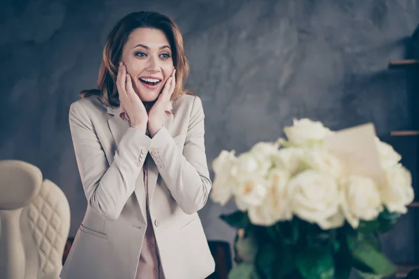 Close-up portret van mooi aantrekkelijk blij blij vrolijk volwassen dame ceo baas chief director professionele vakantie dag op zoek naar frisse witte rozen op industriële stijl interieur werkplek station — Stockfoto