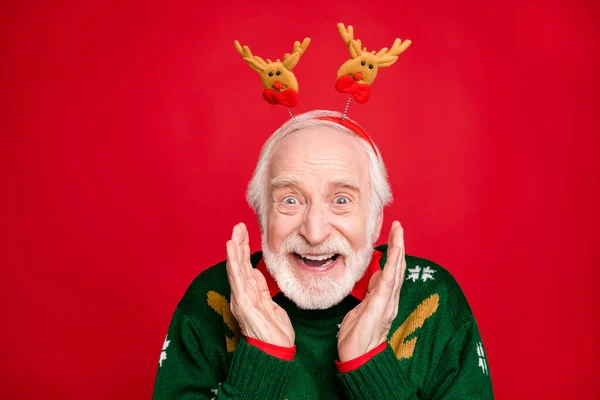 Photo of funny santa man pretty horns on head glad newyear surprise children visit hold arms near cheekbones wear x-mas ugly ornament sweater isolated red background — Stock Photo, Image
