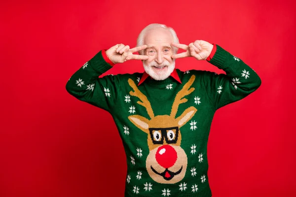 Retrato de positivo alegre homem velho funky desfrutar de Natal tema mascarada festa desgaste estilo elegante chifre design padrão pulôver isolado sobre fundo de cor vermelha — Fotografia de Stock