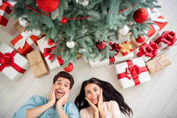 Nahoře nad úhlem fotografie dvou ohromen lidí, kteří mají dárkové krabice na Vánoce těšit x-mas party ležící na podlaze v domě uvnitř — Stock fotografie