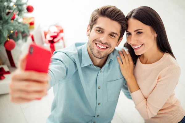 Close up foto de duas pessoas cônjuges alegres fazendo selfie no telefone celular sentado no chão desfrutar de Natal tempo x-mas feriados em casa dentro de casa — Fotografia de Stock