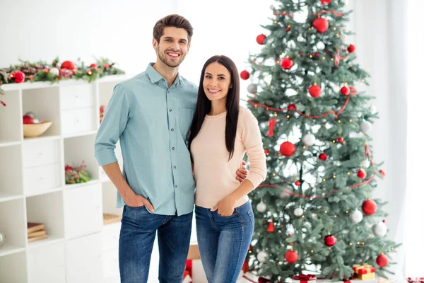 Portret dwóch uroczych romantyków przytulić cieszyć Boże Narodzenie czas x-mas wakacje noszenie różowy niebieski pullover dżinsy dżinsy w domu z dekoracji noel wewnątrz — Zdjęcie stockowe
