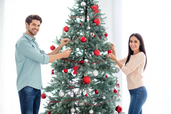 Portret van twee personen echtgenoten versieren groenblijvende dennenboom genieten van noel traditie vieren kerst tijd voor te bereiden op x-mas in huis binnen — Stockfoto