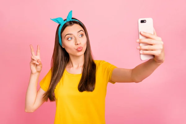 Porträt von niedlichen Teenager mit blauem Stirnband machen Foto V-Zeichen tragen gelbes T-Shirt isoliert über rosa Hintergrund — Stockfoto